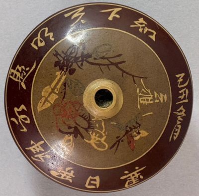 a brown plate with asian writing on it on a table
