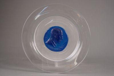 une pièce bleue dans un bol transparent posé sur une surface blanche
