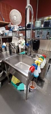 a kitchen with a sink and a lot of cleaning supplies