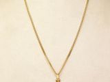 a gold cross pendant on a mannequin torso