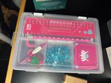 a plastic box with various items in it on a table