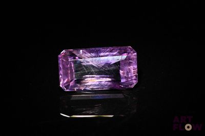 a purple amethorate stone on a black surface
