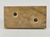 marble block with holes in the middle on a white surface