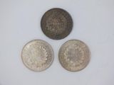 three different types of coins are shown on a white surface
