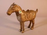 un cheval en or auquel est accrochée une étiquette