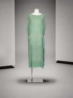 une photo d'une robe verte posée sur un mannequin dans une pièce