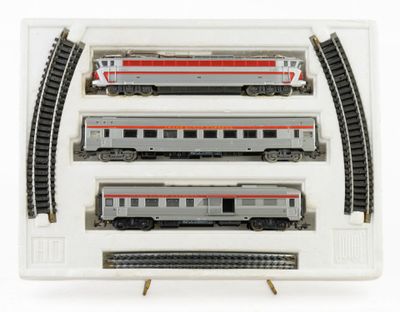 three model trains in a display case on a white surface