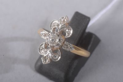 une photo d'une bague ornée d'une fleur en diamant, posée sur un présentoir à bagues