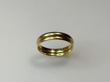 gros plan d'une bague en or sur une surface blanche