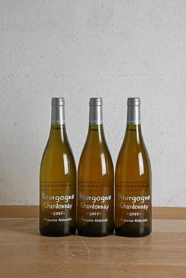 trois bouteilles de vin posées sur une table en bois