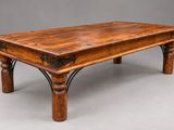 une vieille table basse en bois avec des pieds en fer et un plateau en bois