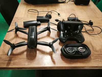 une table sur laquelle se trouvent une télécommande et un petit drone