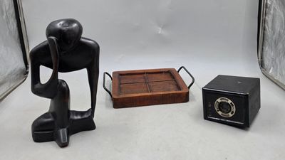 a statue of a man sitting on a chair next to a small box