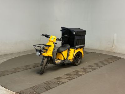 un scooter jaune avec un coffre noir à l'arrière