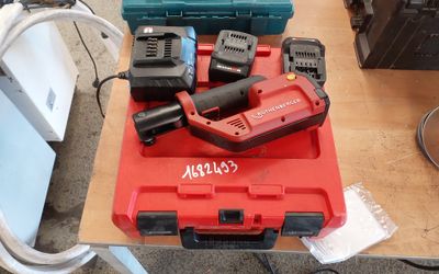 une boîte à outils rouge posée sur une table, avec des outils dessus