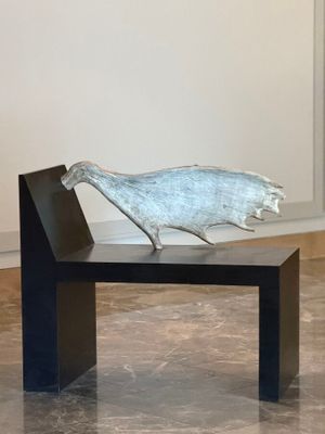 a sculpture of a bird sitting on top of a bench
