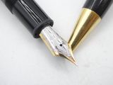 two fountain pens sitting next to each other on top of a table