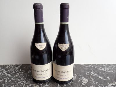 two bottles of wine sitting on top of a table next to each other