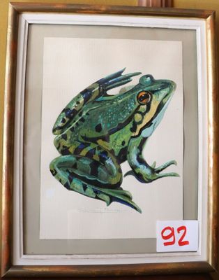 tableau représentant une grenouille verte dans un cadre doré, accroché à un mur jaune