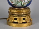 a blue and white vase on a stand with a gold base