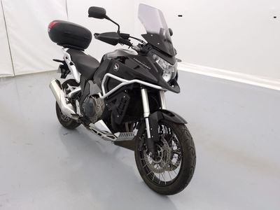 une moto noire garée dans une pièce aux murs blancs