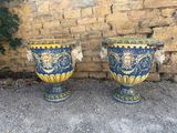 two large vases sitting next to each other on the ground