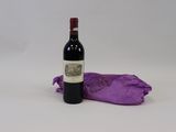 une bouteille de vin posée à côté d'un sac violet