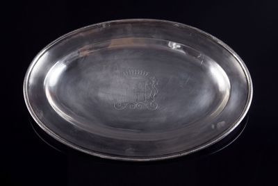 une assiette ancienne en argent ornée d'une couronne sur fond noir