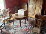 a living room with a rug, chair, table, and other furniture