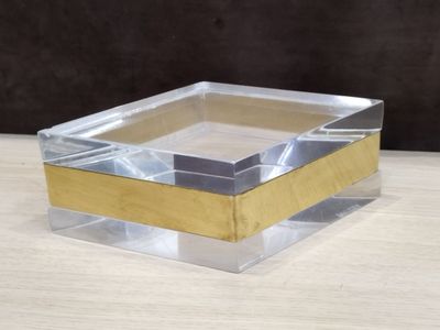 a clear glass box with a gold edge on a wooden table