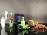 many different vases on a black table with a gray background