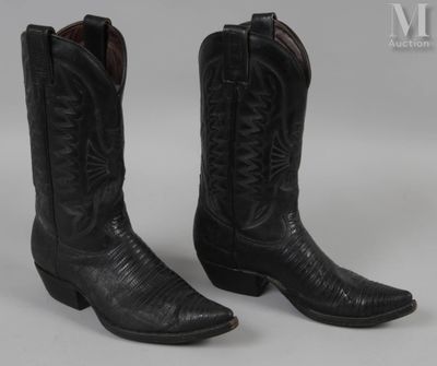 une paire de bottes de cow-boy noires sur fond blanc