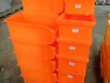 many orange bins stacked on a pallet in a warehouse