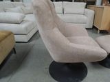 a beige chair and ottoman in a room with furniture