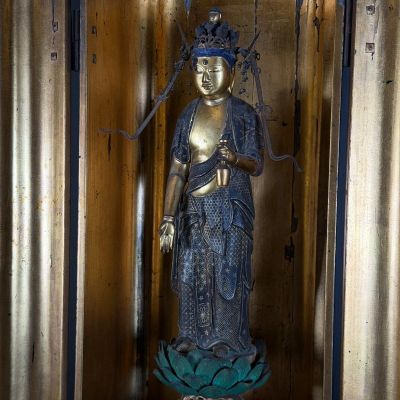 une statue représentant une femme tenant une fleur dans une pièce