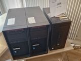 three computers that are sitting on top of a wooden table
