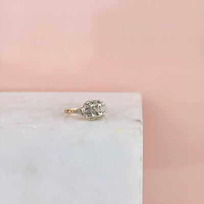 un gros plan d'une bague de fiançailles en diamant posée sur un bloc de marbre
