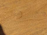 a close up of a wooden table with a white wall in the background