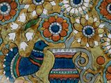 a decorative plate with a bird and flowers on it