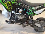 a green and black dirt bike parked on a tile floor