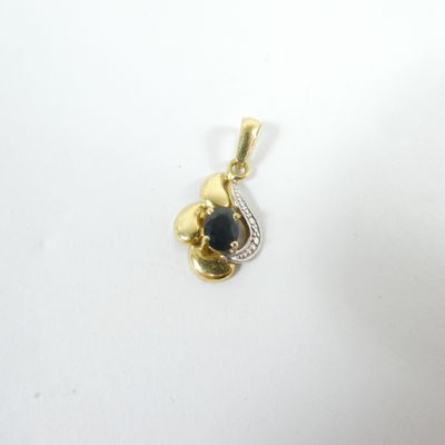 un gros plan d'un pendentif en or orné d'une pierre bleue