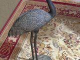 a statue of a bird on a rug on the floor