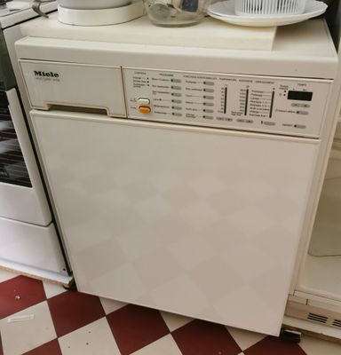 un lave-vaisselle blanc posé sur un autre lave-vaisselle dans une cuisine
