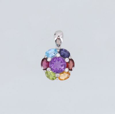 un gros plan d'un pendentif en pierre multicolore sur fond blanc