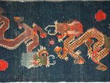 an oriental rug with a dragon design on a blue background