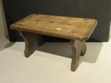 an old wooden stool sitting on top of a white floor