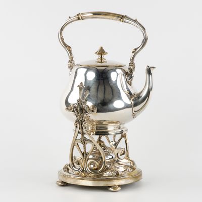 une théière ancienne en argent, munie d'une anse et d'un support