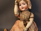 a doll that is sitting on the ground with a hat on