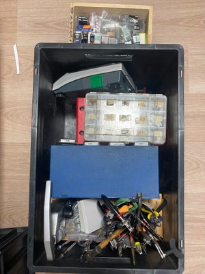 a black box filled with assorted items on a wooden floor
