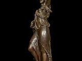 bronze statue of a woman holding a bird on a black background